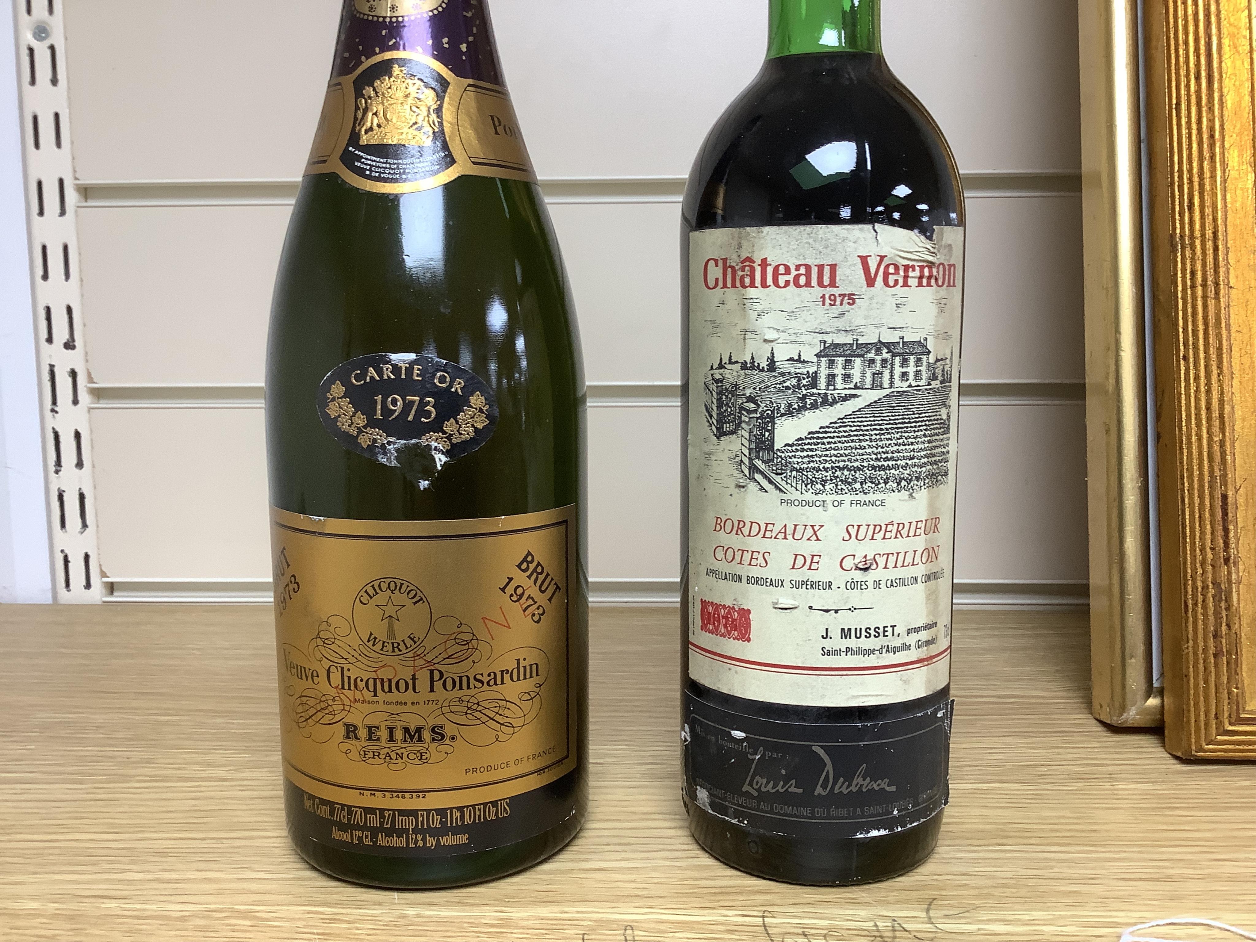 A bottle of 1973 Veuve Clicquot Ponsardin champagne and a bottle of 1975 Chateau Vernon. Condition - fair
